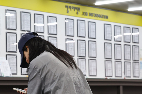 A job seeker waits for a consultation session in front of a board displaying notices at an employment center in Mapo District, western Seoul. [YONHAP]