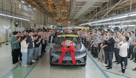 Renault Korea officials and employees hold a celebration for the first unit of the Grand Koleos, the company's new hybrid SUV, at a manufacturing plant in Busan on Monday. [RENAULT KOREA]