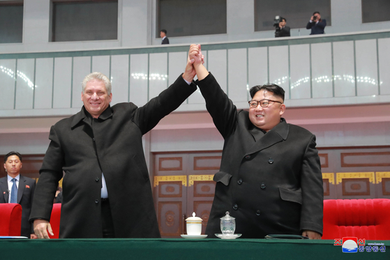 North Korean leader Kim Jong-un, right, and Cuban President Miguel Mario Diaz-Canel Bermudez hold up their hands as they watch a mass games performance in Pyongyang on Nov. 5, 2018, in a photo from the North's Rodong Sinmun newspaper. [YONHAP]