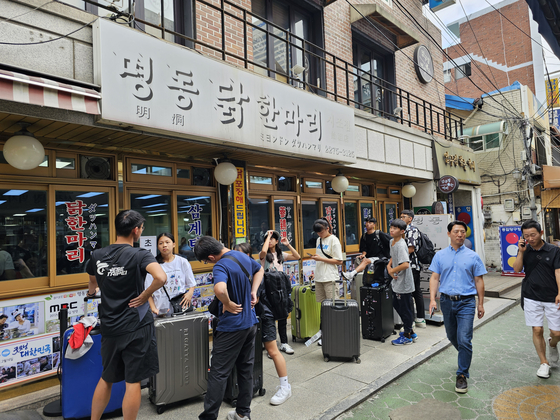 Patrons wait in a long line at the newly opened chicken soup restaurant in Sinjin Market, Jongno District, central Seoul, at 11:30 a.m. on Monday.