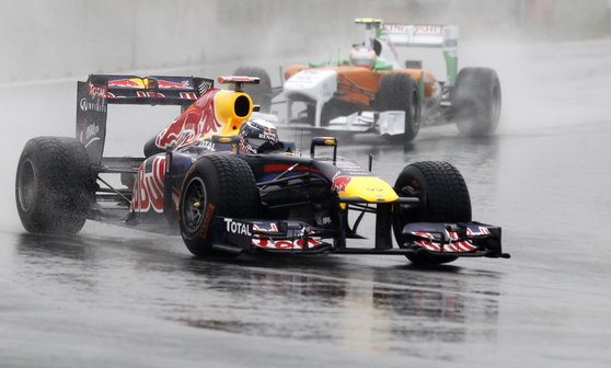 Red Bull driver Sebastian Vettel takes a corner followed by Sahara Force India driver Paul di Resta during the first practice session of the 2011 Korean Grand Prix at the Korea International Circuit in Yeongam, South Jeolla on Oct. 14, 2011.  [REUTERS/YONHAP]