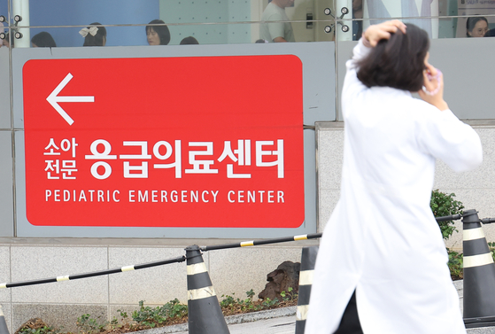 A medical professional walks by a sign for a pediatric emergency room in a general hospital in Seoul on Wednesday. [YONHAP] 