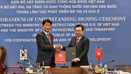 Korean Land Minister Park Sang-woo, left, and his Vietnamese counterpart, Nguyen Thanh Nghi, shake hands at a signing ceremony on July 16, 2024, in Hanoi for a memorandum of understanding regarding cooperation on urban and social housing development. [YONHAP]
