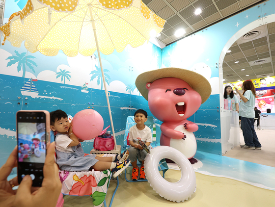 Visitors take a picture in front of the Zanmang Loopy character installation at the Character Licensing Fair 2024 held at Coex, southern Seoul, on July 18. [YONHAP]