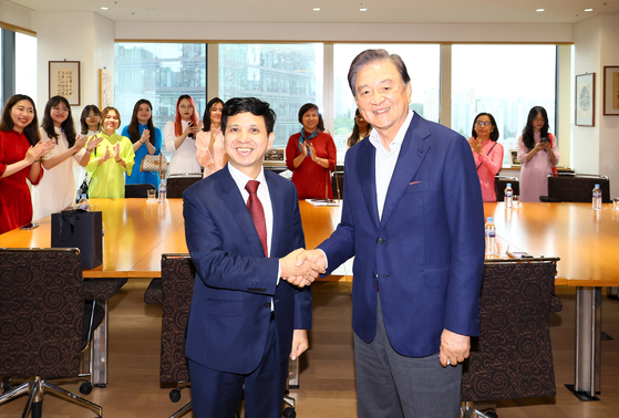 Chairman of JoongAng Holdings and the Korea Peace Foundation Hong Seok-hyun, right, shakes hands with Hoang Van Haim, an official from the Diplomatic Academy of Vietnam, at the HSBC Building in Jung District, central Seoul, on Wednesday. [KIM HYUN-DONG]