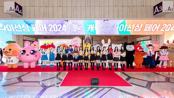 Members of girl group tripleS, the honorary ambassador of the Character Licensing Fair 2024, pose for photos with the fair's characters at Coex, southern Seoul, on July 18. [KOCCA]