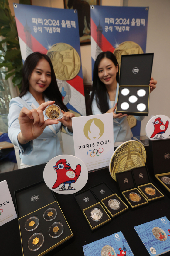 Models pose with commemorative coins for the 2024 Paris Olympics during a showcase at the embassy of France in Seodaemun District, western Seoul. [YONHAP]