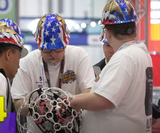 Players inspect a drone ball before a game in a video provided by the Camtic Institute of Technology. [CAMTIC INSTITUE OF TECHNOLOGY]