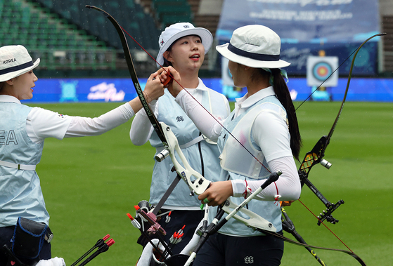 Jeon Hun-young, left, Lim Si-hyeon and Nam Suh-yun of the national archery team cheer during a special match ahead of a K League game at Jeonju World Cup Stadium in Jeonju, North Jeolla on June 29. [NEWS1]