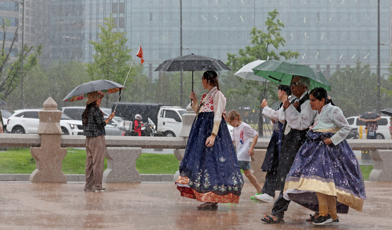 Tourists visiting Gyeongbok Palace in Jongno District, central Seoul, carry umbrellas to avoid rain as heavy downpours and strong winds hit on Monday. Some areas in the greater Seoul region experienced rainfall rates of 20 to 30 millimeters per hour. The downpour is expected to continue overnight, with rainfall in the greater Seoul area forecast to reach 30 to 50 millimeters per hour on Tuesday. [NEWS1]
