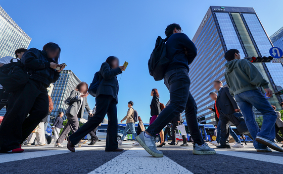 Pedestrians cross a road to head to work during the morning rush hour in central Seoul on May 16. [YONHAP]