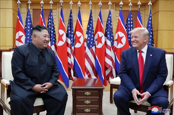 North Korea's leader Kim Jong-un, left, and former U.S. President Donald Trump smile during a meeting on the south side of the Military Demarcation Line that divides South and North Korea on June 30, 2019. [YONHAP]
