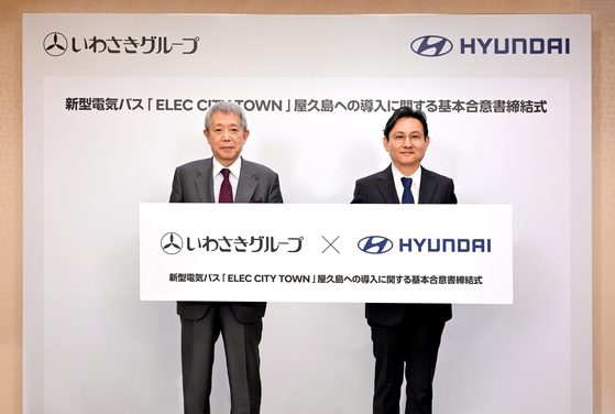 Hyundai Mobility Japan CEO Cho Won-sang, right, poses with Iwasaki Group CEO Yoshitaro Iwasaki after signing a letter of intent to supply five electric buses to the company on Thursday. The Elec City Town buses will run on routes on Yakushima Island. [HYUNDAI MOTOR]
