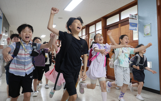 Students at Shinpoong Elementary School in Suwon, Gyeonggi, dash down the hallway with joy on Tuesday as summer vacation officially begins. [NEWS1]