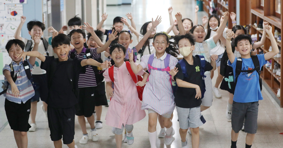 Students race down the hallway in excitement as summer break begins at Shinpoong Elementary School in Suwon, Gyeonggi, on Tuesday. [NEWS1]