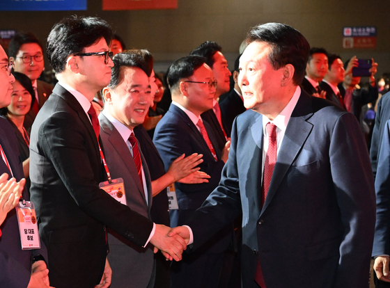 President Yoon Suk Yeol, right, shakes hands with Han Dong-hoon, left, the new People Power Party leader, during a national convention held at Kintex in Goyang, Gyeonggi, on Tuesday. [JOINT PRESS CORPS]
