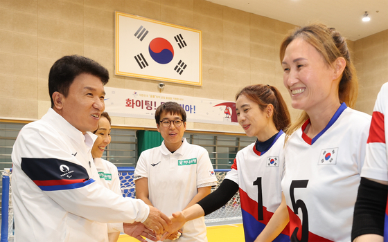 Hana Financial Group Chairman and CEO Ham Young-joo, left, shakes hands with Team Korea athletes competing in goalball at the upcoming Paris 2024 Paralympic Games during a visit to the Icheon National Training Center in Gyeonggi on Tuesday. [HANA FINANCIAL GROUP] 