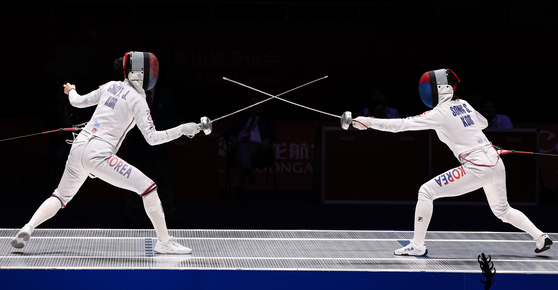 Choi In-jeong, left, and Song Se-ra compete in the women's epee final at the Hangzhou Asian Games in Hangzhou, China on Sept. 28, 2023.  [NEWS1]