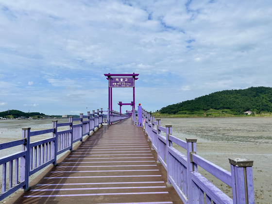The Purple Bridge on Purple Island, Shinan County, connects the Banwol and Bakji islands and allows visitors to cross over the mud flats on foot. [SHIN MIN-HEE]
