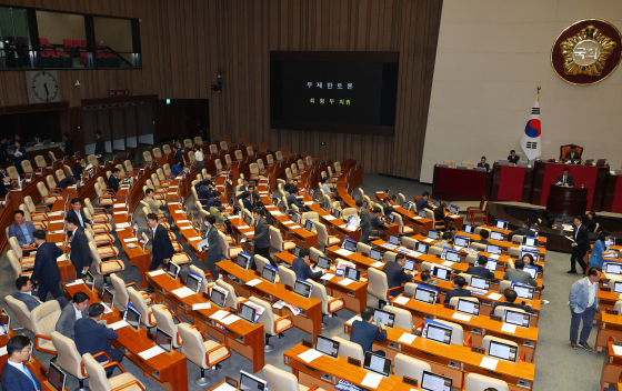 Lawmakers begin to exit the main chamber of the National Assembly in Yeouido, western Seoul, after the conservative People Power Party started its filibuster against one of four controversial bills aimed at reducing the government's influence over public broadcasters. [YONHAP]