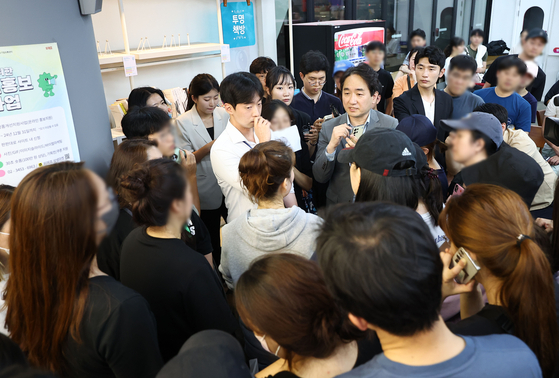 WeMakePrice co-CEO Ryu Hwa-hyun talks with customers demanding refunds at the e-commerce platform's headquarters in Gangnam District, southern Seoul, on Thursday. [YONHAP]