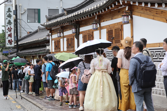 People line up outside a samgyetang restaurant in downtown Seoul to enjoy the popular traditional chicken soup dish Thursday, marking jungbok, the beginning of the second phase of the midsummer heat. Koreans eat chicken on this day to replenish their energy. [YONHAP]