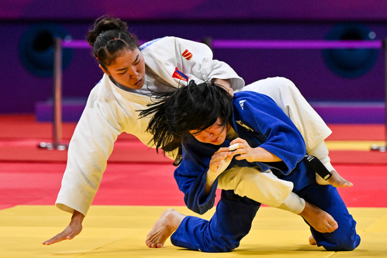 Korea's Huh Mi-mi, right, and Mongolia's Batsuuri Nyam-Erdene compete in a mixed team bronze medal match at the Hangzhou Asian Games in Hangzhou, China on Sept. 27, 2023. [AFP/YONHAP]