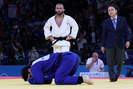 Korea's Kim Won-jin, bottom, competes against France's Luka Mkheidze in the men's judo -60-kilogram quarterfinal bout at the Paris Olympics in Paris on Saturday. [AFP/YONHAP]