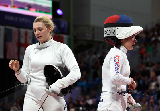 Korean fencer Song Se-ra, right, reacts after losing to Eszter Muhari of Hungary in the women’s epee individual table of 16 at the Paris Olympics at Grand Palais in Paris on Saturday. [JOINT PRESS CORPS] 