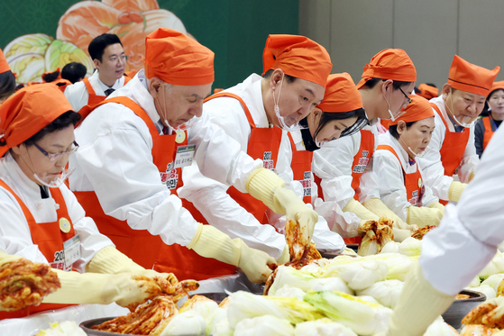 President Yoon Suk Yeol, center, makes kimchi at a kimjang event calling for national unity through goodwill and sharing at Kintex in Goyang, Gyeonggi, on Monday. Goldberg stands to the left of Yoon. [JOINT PRESS CORPS]