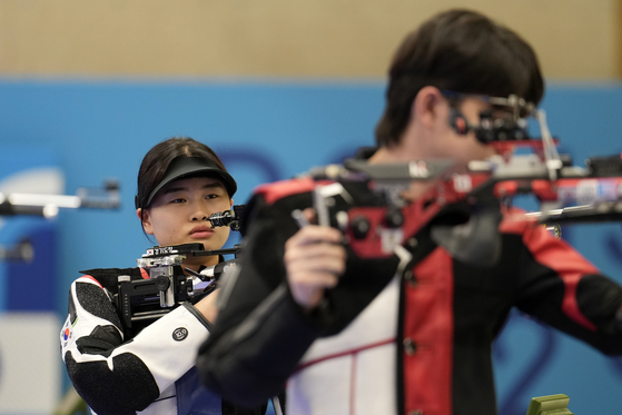 Korea's Keum Ji-hyeon, left, and teammate Park Ha-jun compete in the 10-meter air rifle mixed gold medal round at the 2024 Paris Olympics on Saturday in Chateauroux, France. [AP/YONHAP]