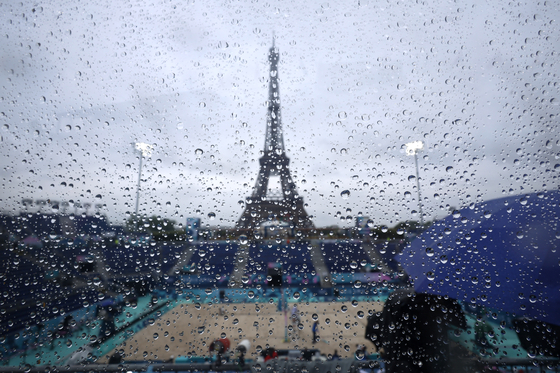 Rain is visible before the start of the men's beach volleyball tournament at Eiffel Tower Stadium in Paris on Saturday.  [REUTERS/YONHAP]
