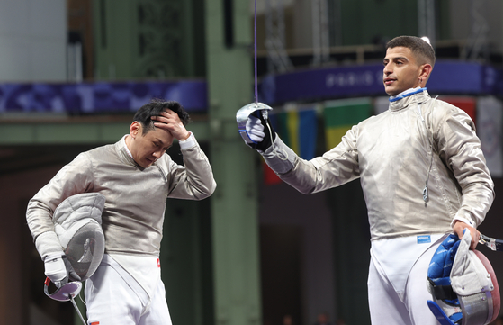 Gu Bon-gil, left, reacts after losing the round of 32 in the individual men's sabre event on Saturday in Paris. [YONHAP]