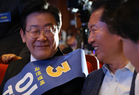 Rep. Lee Jae-myung, left, smiles as he talks to Democratic Party Supreme Council members Jeong Chung-rae, middle, and Seo Young-kyo, right, before candidates for the party's leadership positions deliver their speeches at a convention center in Cheongju, North Chungcheong, on Sunday. [YONHAP] 