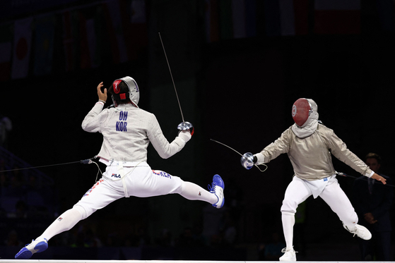 Korea's Oh Sang-uk, left, and Tunisia's Fares Ferjani compete in the men's sabre individual gold medal bout during the Paris 2024 Olympics at the Grand Palais in Paris on Saturday.  [AFP/YONHAP]