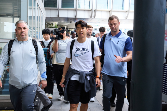 Spurs captain Son Heung-min, center, leaves the airport with his team, wearing a backpack and a jacket tied around his waist. [COUPANG PLAY]