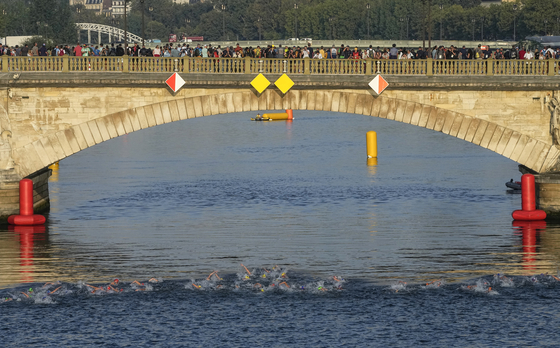 Athletes swim in the Seine on the first leg of the women's triathlon test event for the Paris Olympics in Paris, on Aug. 17, 2023. [AP/YONHAP]