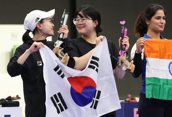 Korea's Kim Ye-ji, left, and Oh Ye-jin celebrate after taking silver and gold, respectively, in the women's 10-meter air pistol at the Paris Olympics on Sunday. [YONHAP]