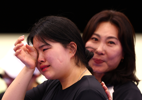 Oh Ye-jin, left, wipes away tears after winning the women's 10-meter air pistol contest at the Chateauroux Shooting Centre in Paris on Sunday. [EPA/YONHAP]
