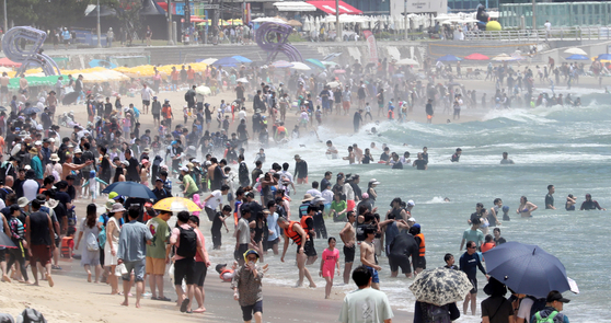 Beachgoers find summertime respite by plunging into ocean water in Haeundae Beach in Busan on Sunday, when the city's daily high is expected to range between 31 and 35 degrees Celsius (87.8 and 95 degrees Fahrenheit). [NEWS1]