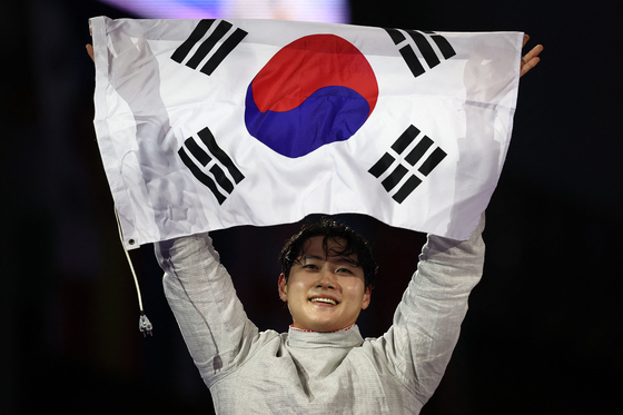 Korea's Oh Sang-uk celebrates after beating Tunisia's Fares Ferjani in the men's sabre individual gold medal bout during the Paris 2024 Olympics at the Grand Palais in Paris on Saturday.  [AFP/YONHAP]