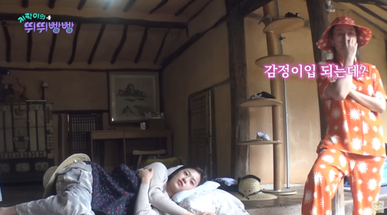 An Yu-jin from the girl group IVE, left, and rapper Lee Young-ji take a break at a hanok, a traditional Korean house, in the reality TV show “Earth Arcade’s Vroom Vroom” on tvN. [TVN] 