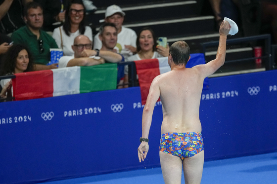 A lifeguard gestures to the crowd after retrieving United States swimmer Emma Webber's swimming cap from the bottom of the pool during the morning session at the 2024 Paris Olympics in Paris on Sunday.  [AP/YONHAP]