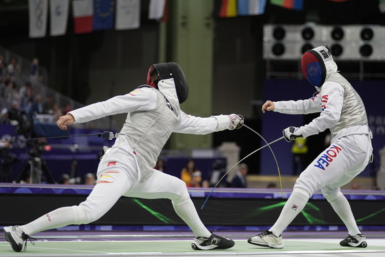Korean fencer Ha Tae-gyu, right, competes against Carlos Llavador of Spain in the men's foil individual table of 32 at the Paris Olympics at Grand Palais in Paris on Monday. [AP/YONHAP] 