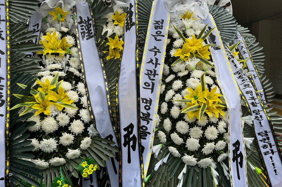 Condolence flowers at Gwanak Police Station in southern Seoul on July 23 honor an inspector surnamed Song, who took his life on July 18 after complaining of an excessive workload. [YONHAP]
