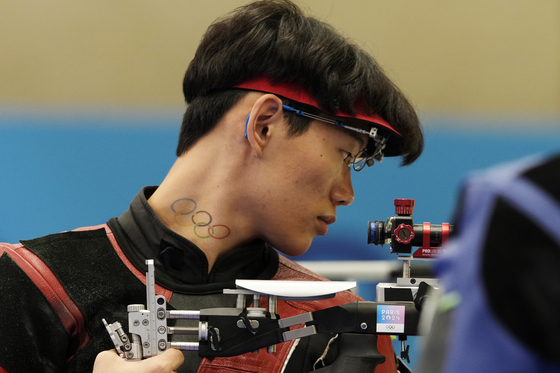 Korea's Choe Dae-han, with the Olympic rings on his neck, prepares to compete in the 10-meter air rifle men's final at the 2024 Paris Olympics in Chateauroux, France on Monday. [AP/YONHAP]