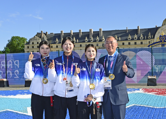 Hyundai Motor Group Executive Chair Euisun Chung, far right, takes a photo with Korean archers as they beat China in the women's team archery gold medal match to win Korea’s 10th straight Olympic gold in the event at the Invalides in Paris on Sunday. [KOREA ARCHERY ASSOCIATION] 