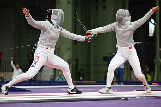 Korea's Choi Se-bin, left, competes against Japan's Misaki Emura in the women's sabre individual round of 16 during the Paris Olympics at the Grand Palais in Paris on Monday.  [AFP/YONHAP]