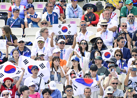 Hyundai Motor Group Executive Chair Euisun Chung, center, holds Korea's national flag, to cheer Korean archers in the women's team archery gold medal match against China at the Invalides in Paris on Sunday. [KOREA ARCHERY ASSOCIATION] 