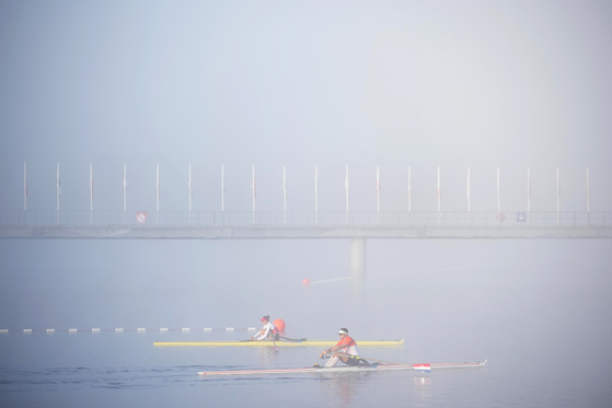 Athletes warm up amid morning fog ahead of the day's rowing competitions in Vaires-sur-Marne, France on Sunday.  [AP/YONHAP]